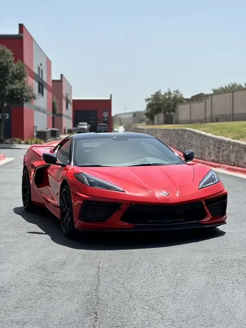 Front view of a red Chevrolet Corvette C8 parked outside Slims Detailing Studio in Round Rock, TX.