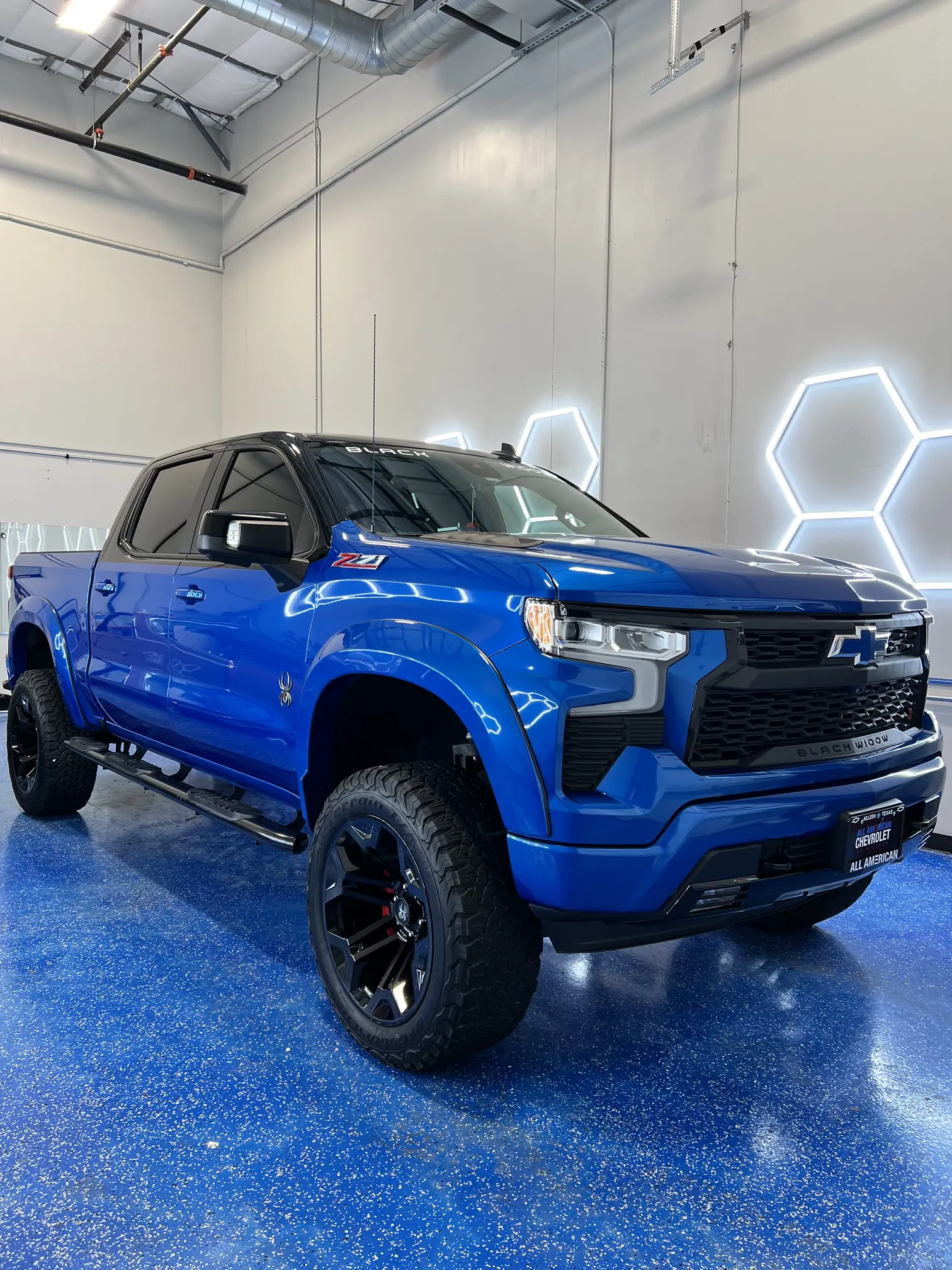 Glossy blue lifted pickup truck after premium paint correction inside our detailing studio in Round Rock TX