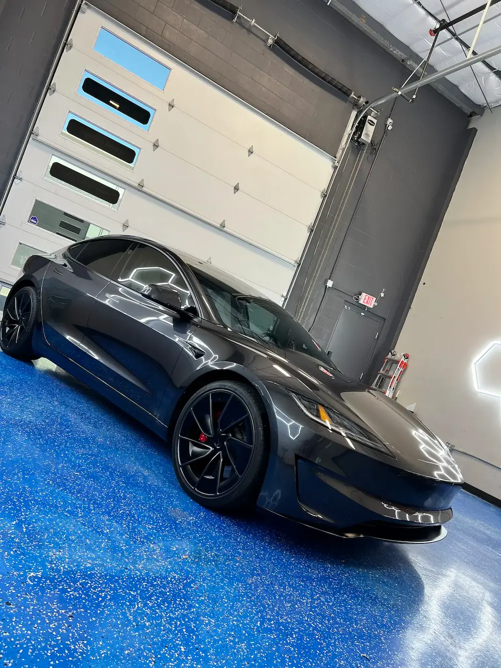 Gray Tesla Model 3 with professional window tint at Slims Detailing Studio in Round Rock, TX.