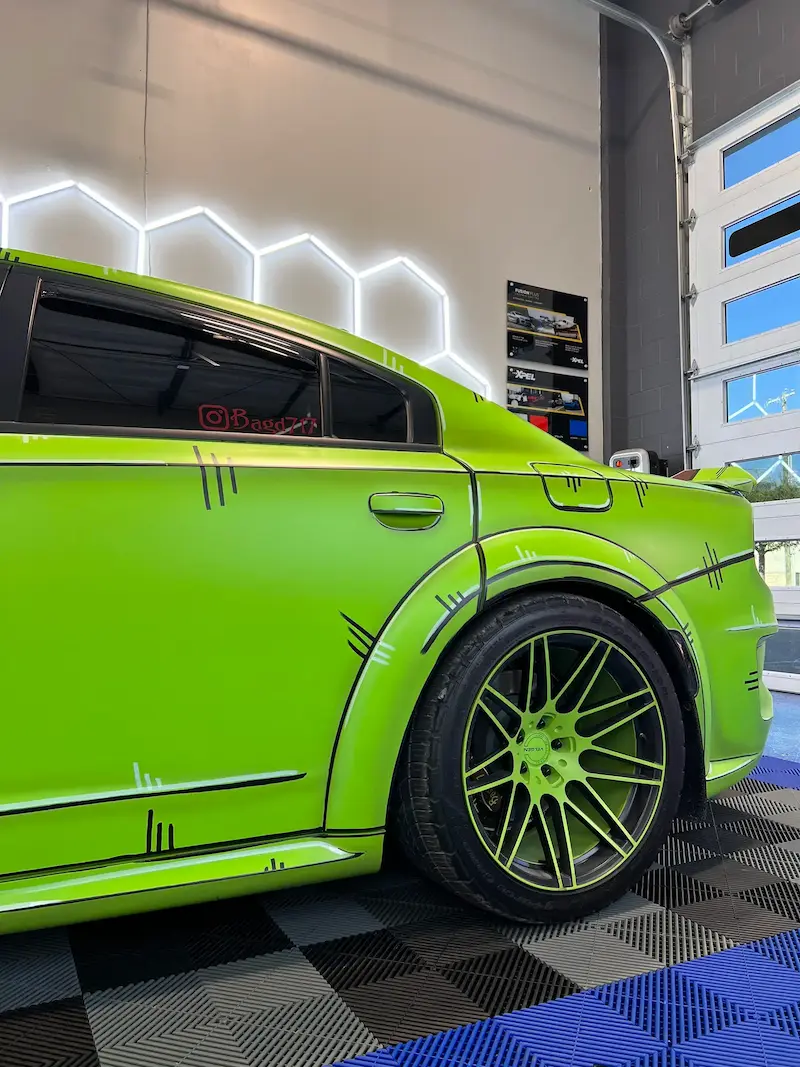 Rear side view of a lime green Dodge Charger SRT with a custom vinyl wrap at Slims Detailing Studio in Round Rock, TX.