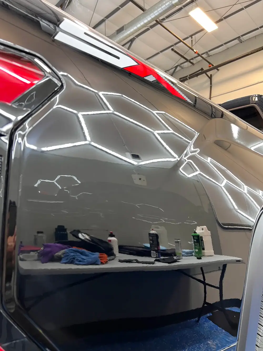 Flawless mirror-like reflection on a black car clear coat after multi-stage paint correction and wet sanding